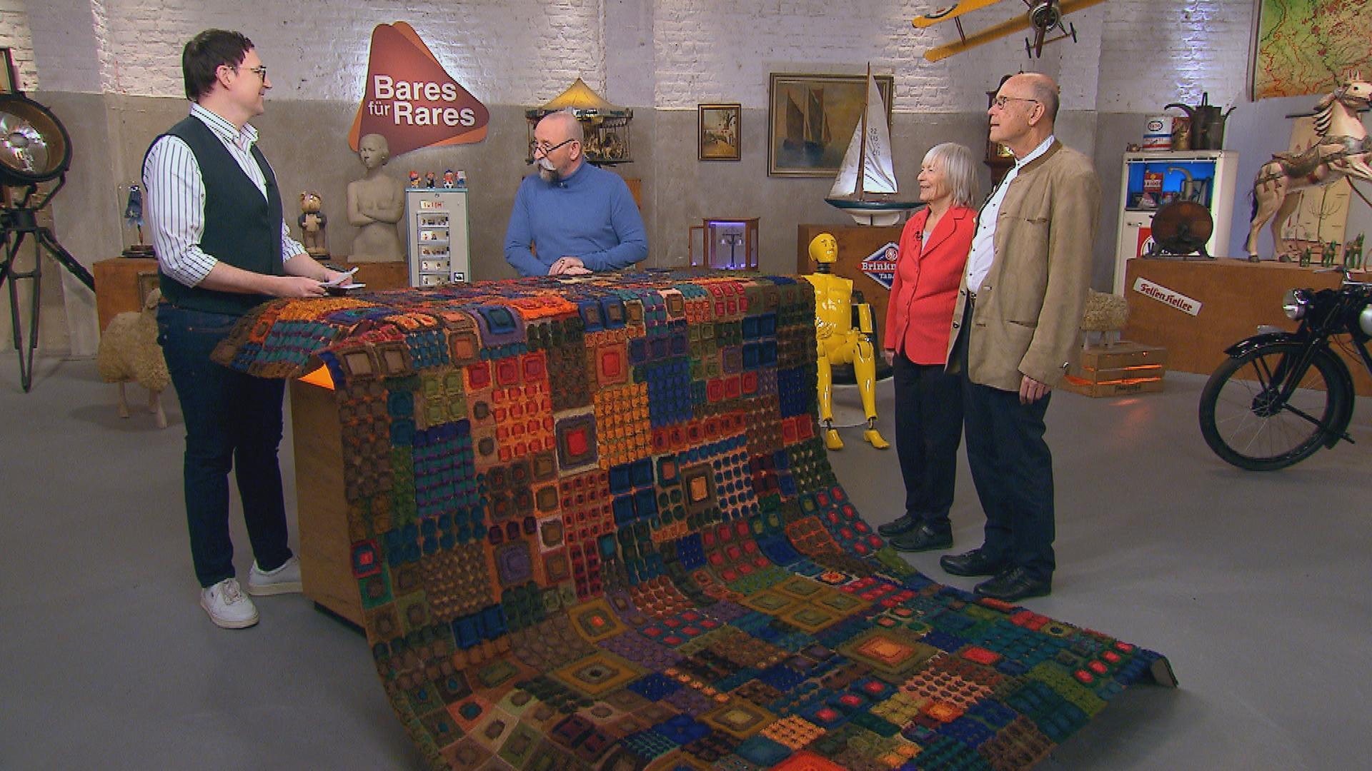 Experte Colmar Schulte-Goltz begutachtet einen Wandbehang von Lotte Hofmann.