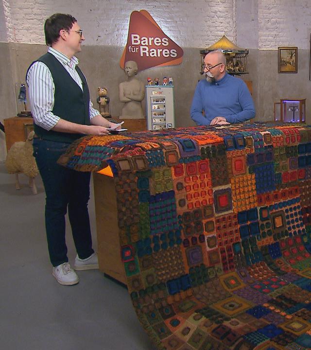 Experte Colmar Schulte-Goltz begutachtet einen Wandbehang von Lotte Hofmann.