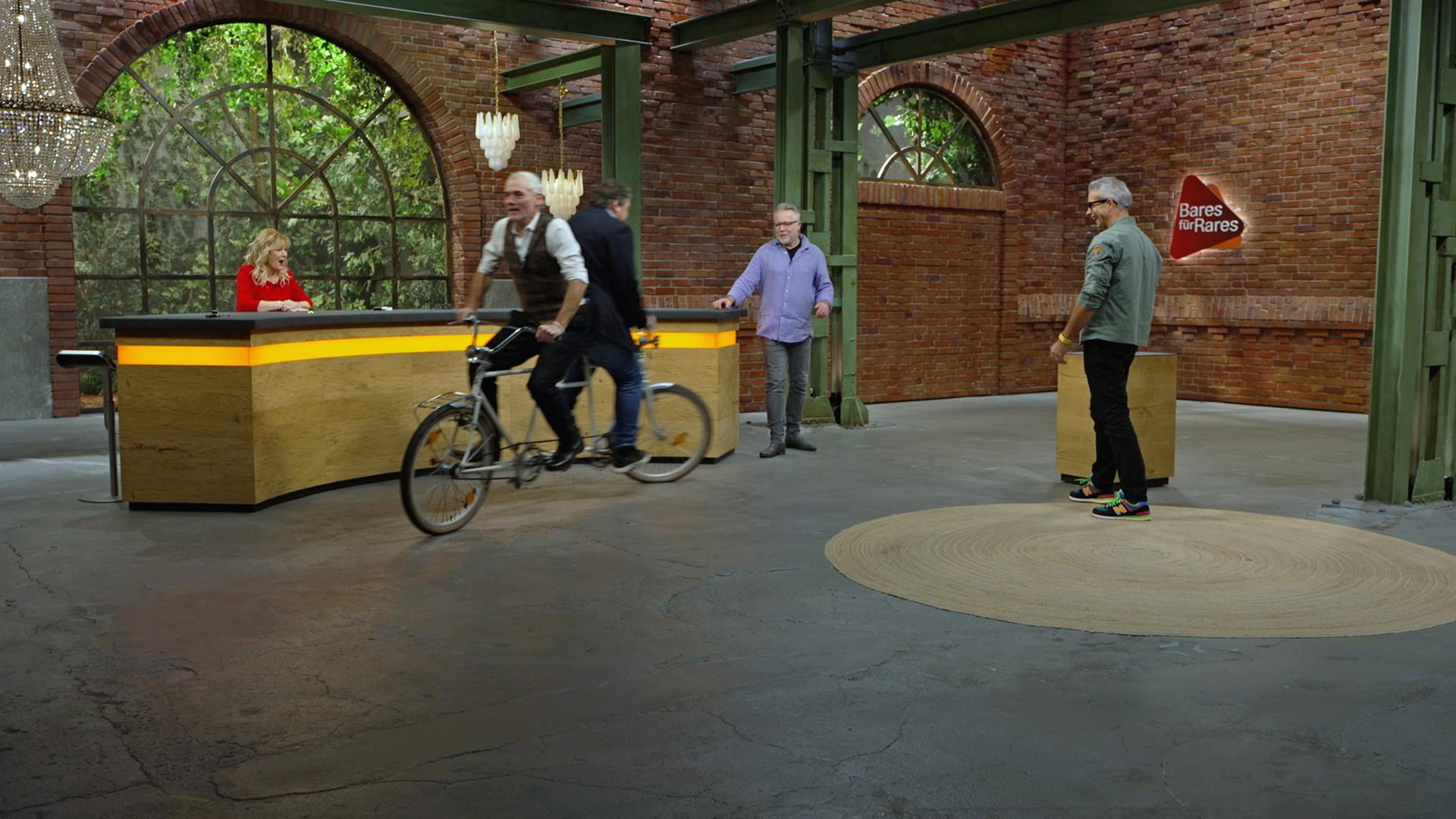 Christian Vechtel und Daniel Meyer fahren mit einem "Rücken an Rücken"-Tandem im Händlerraum.