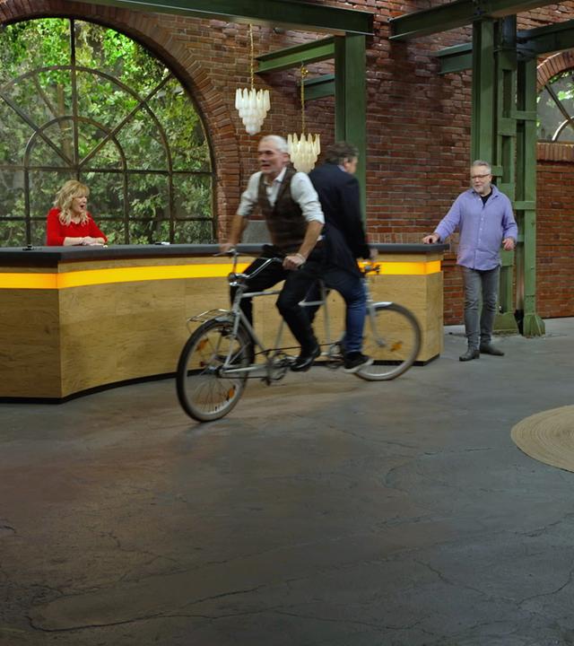 Christian Vechtel und Daniel Meyer fahren mit einem "Rücken an Rücken"-Tandem im Händlerraum.