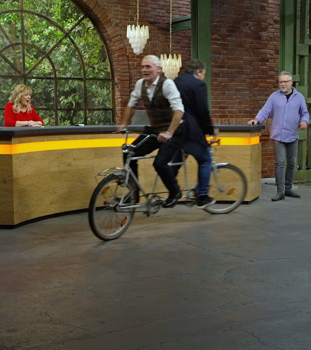 Christian Vechtel und Daniel Meyer fahren mit einem "Rücken an Rücken"-Tandem im Händlerraum.
