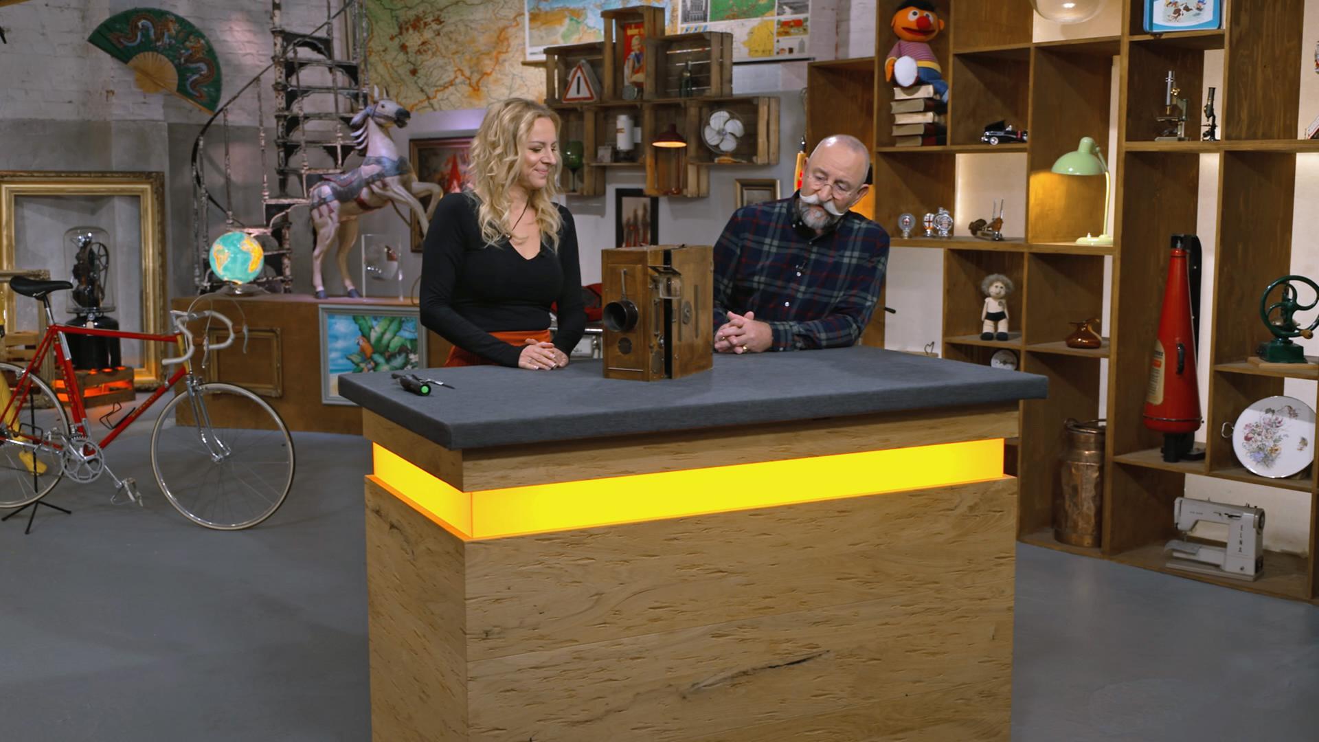Annika Raßbach und Horst Lichter begutachten eine antike Stummfilmkamera.