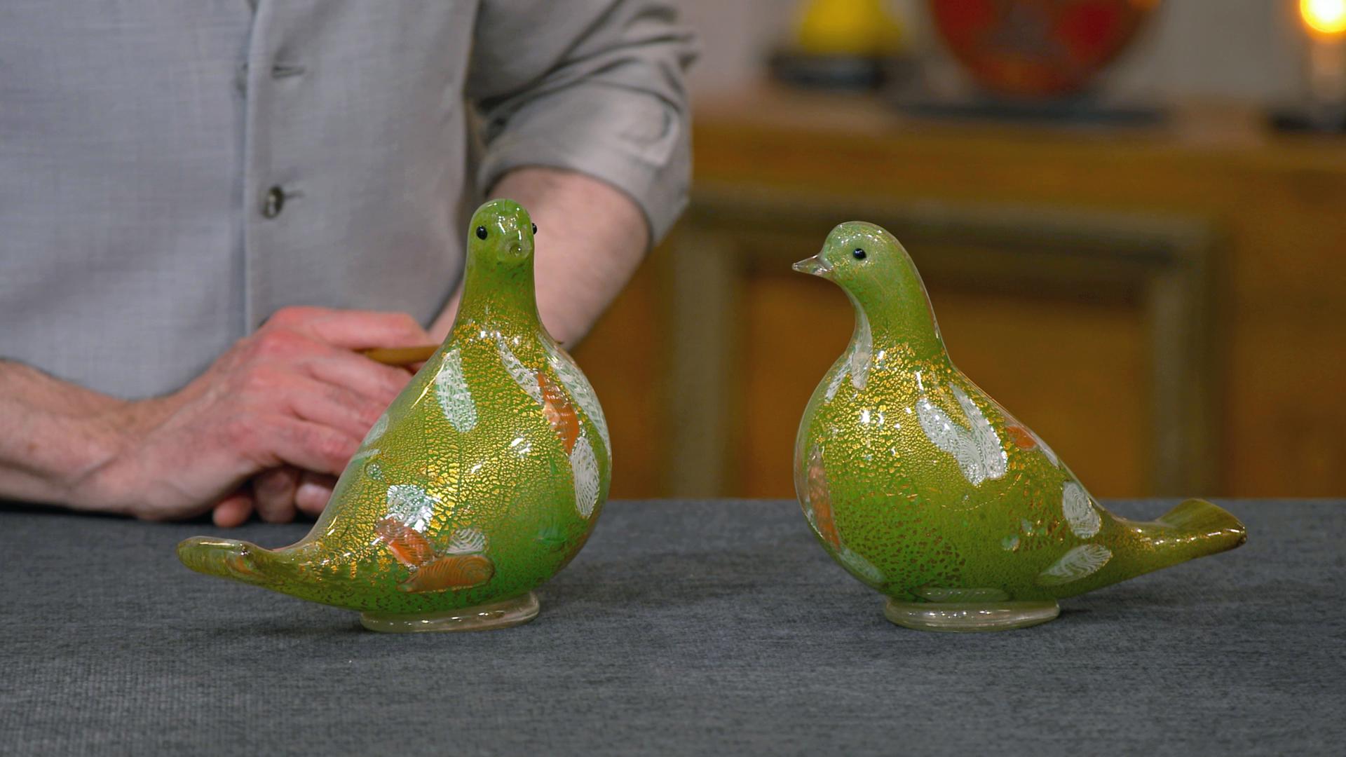 Zwei grüne Murano Glastauben auf dem Expertisentisch.