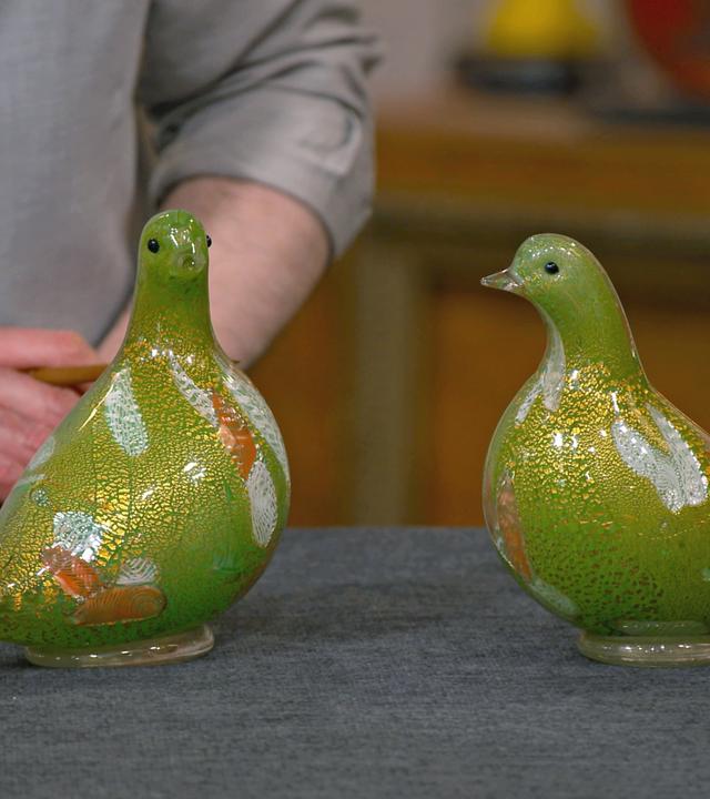 Zwei grüne Murano Glastauben auf dem Expertisentisch.