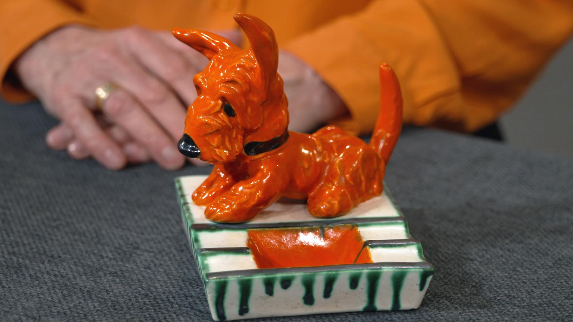 Ein alter Aschenbecher von Goldscheider mit einem orangefarbenen Keramik-Terrier