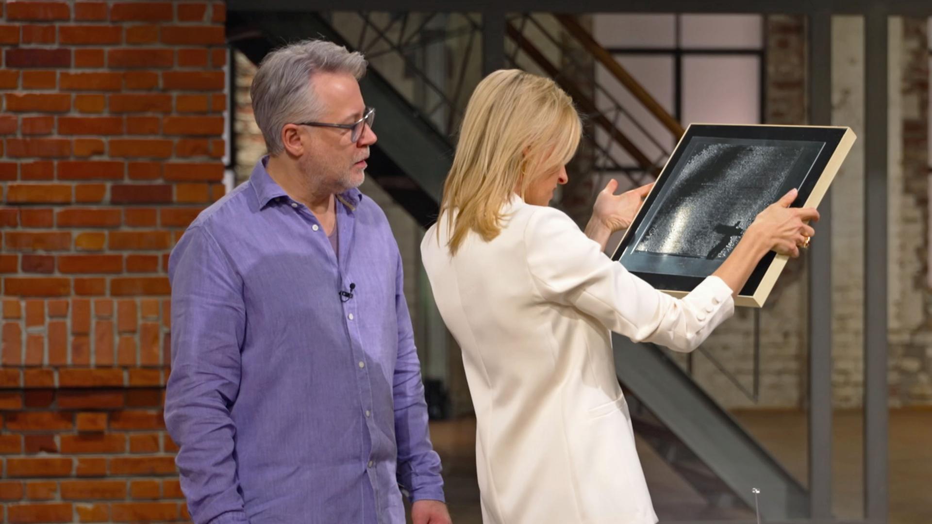 Lisa Nüdling und Jan Čížek betrachten eine bildhafte Darstellung mit dem Titel "Der Tänzer".