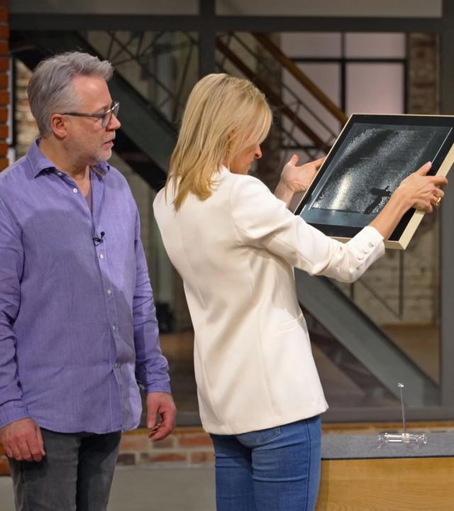 Lisa Nüdling und Jan Čížek betrachten eine bildhafte Darstellung mit dem Titel "Der Tänzer".