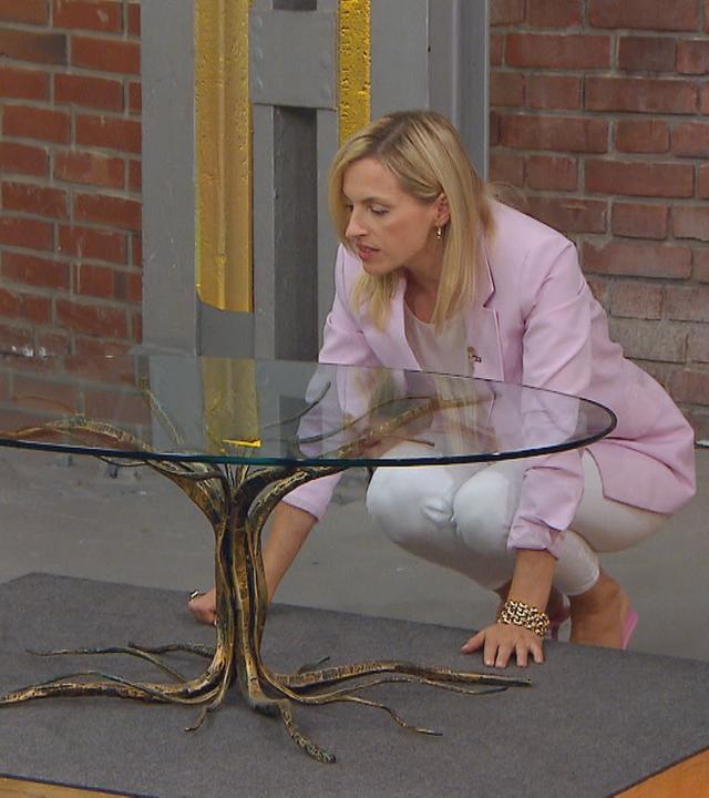 Händlerin Lisa Nüdling hockt hinter einem Couchtisch des Designers Salvino Marsura