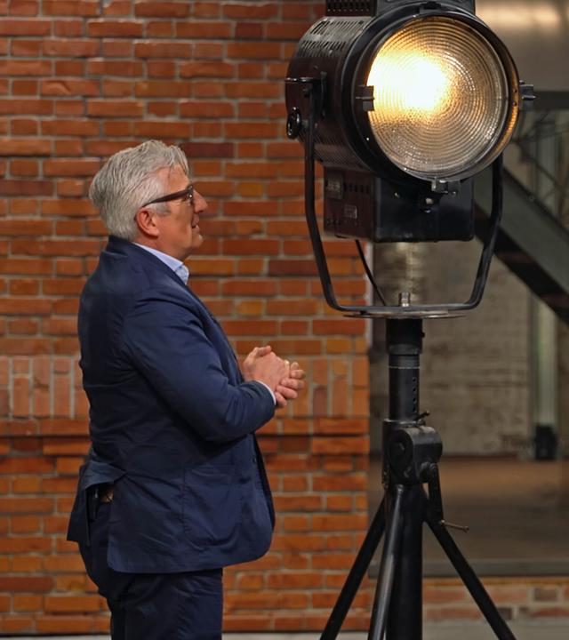 Markus Wildhagen steht neben zwei Filmscheinwerfern aus den 1950er-Jahren.