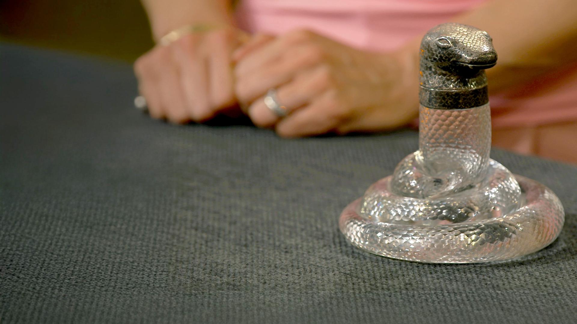 Ein antikes Tintenfass in Form einer Schlange mit einem silbernen Schlangekopf als Verschluss.