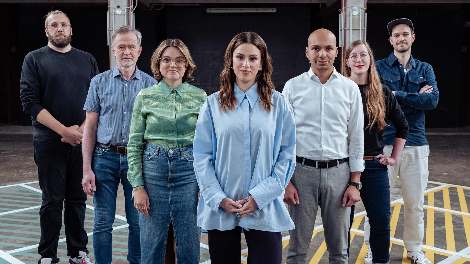 Die Gäste der Sendung stehen auf dem Spielfeld mit Moderatorin Salwa Houmsi.