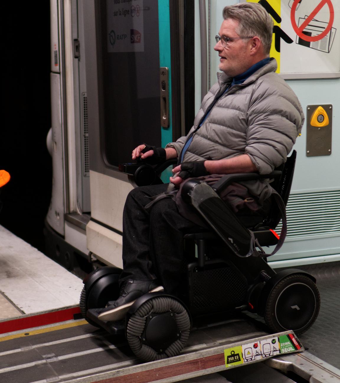 Ein Rollstuhlfahrer nutzt eine Klappe um aus einer Metro in Paris auszusteigen