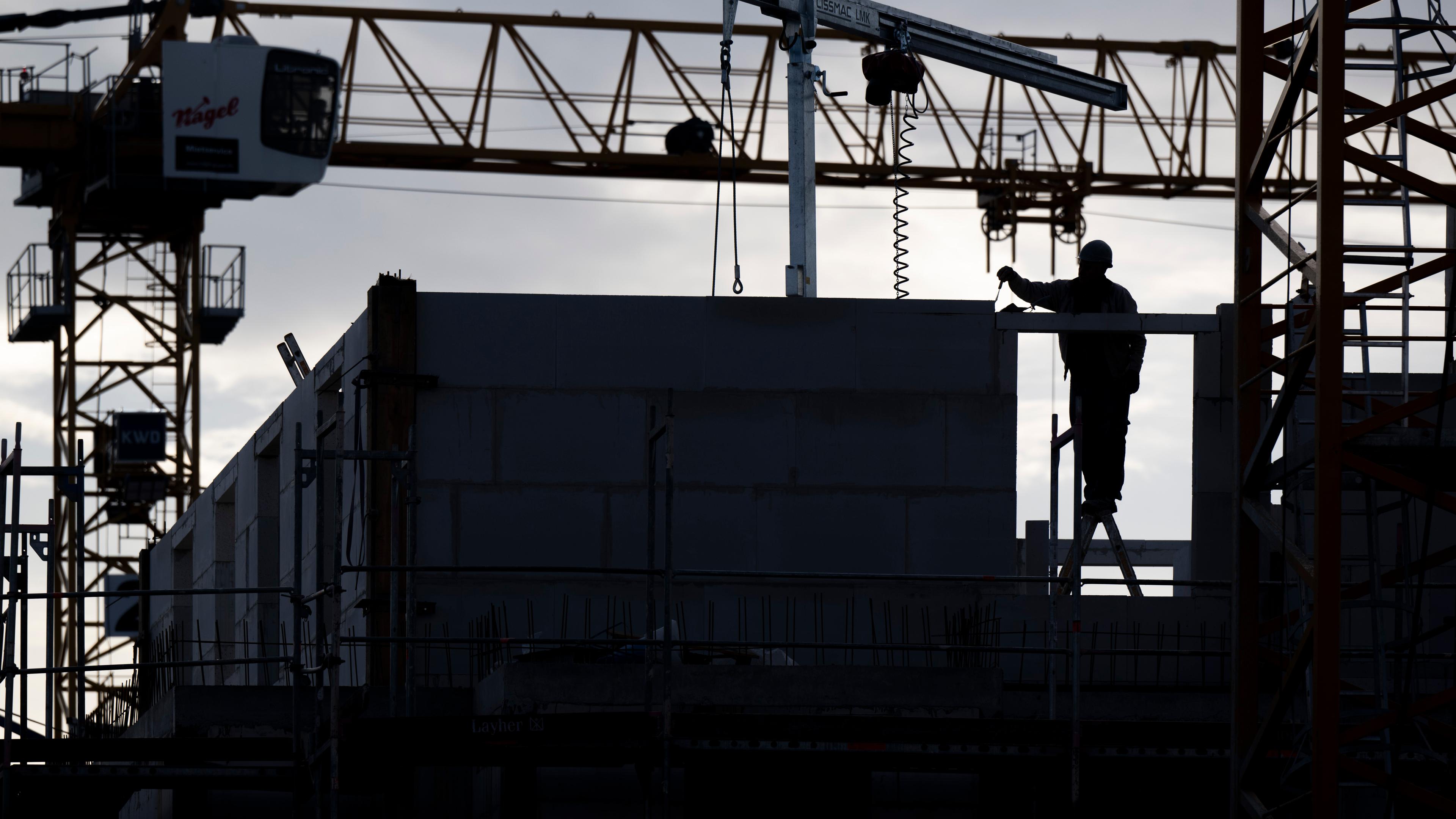 Bauarbeiter arbeitet auf einer Baustelle von einem neu gebauten Wohnhaus