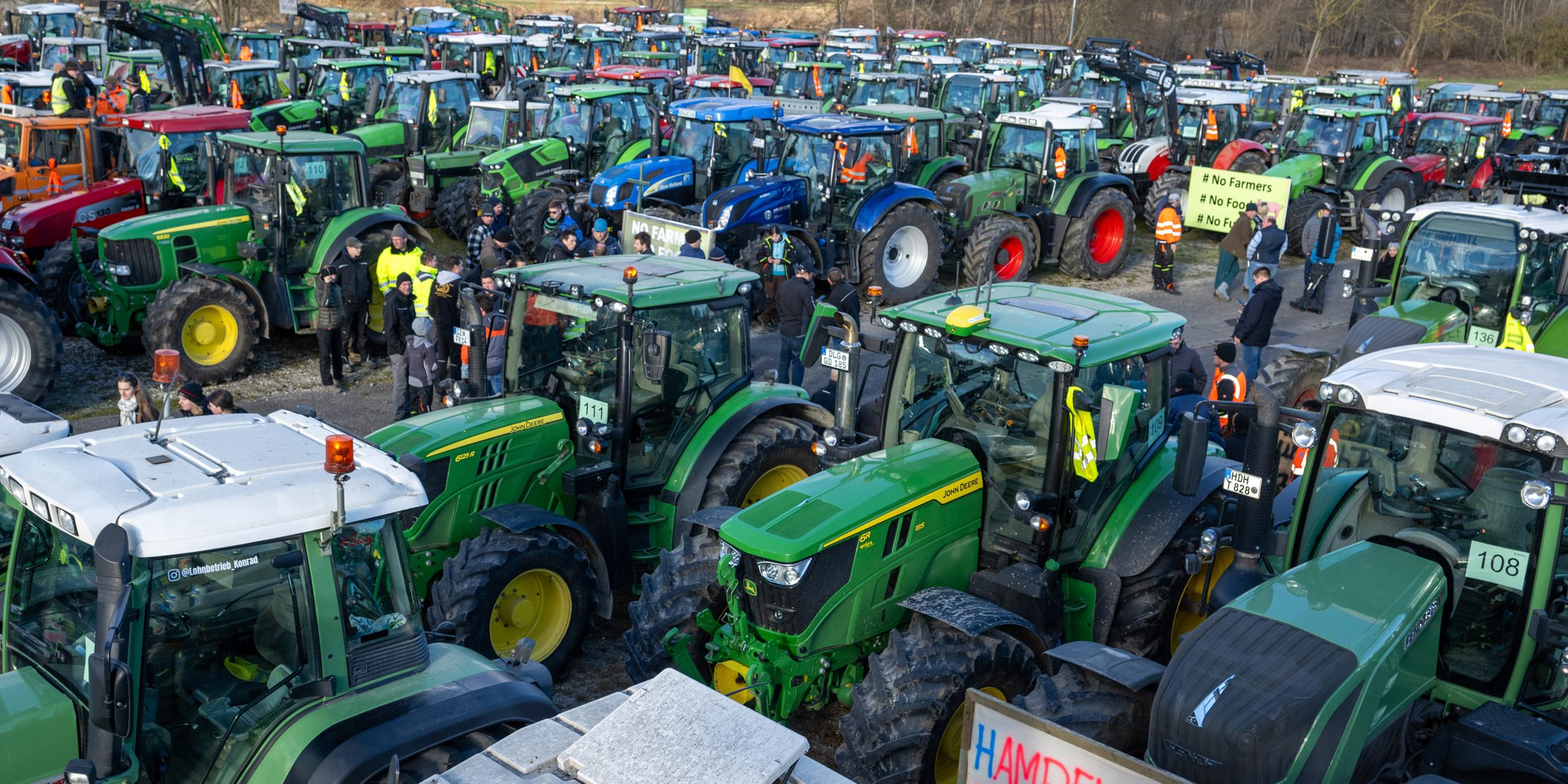 Mehrere hundert Traktoren stehen bei einer Kundgebung des Bauernverbandes gegen die Sparpläne der Bundesregierung auf dem Festplatz.
