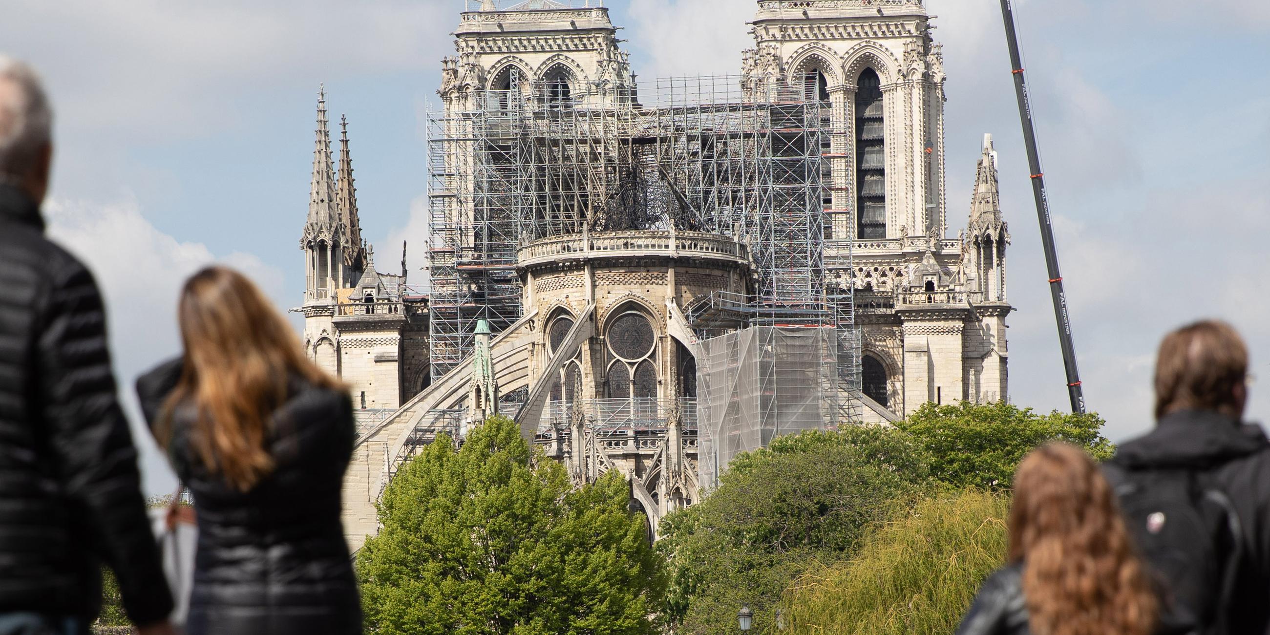 Menschen betrachten ein Baugerüst um Notre Dame