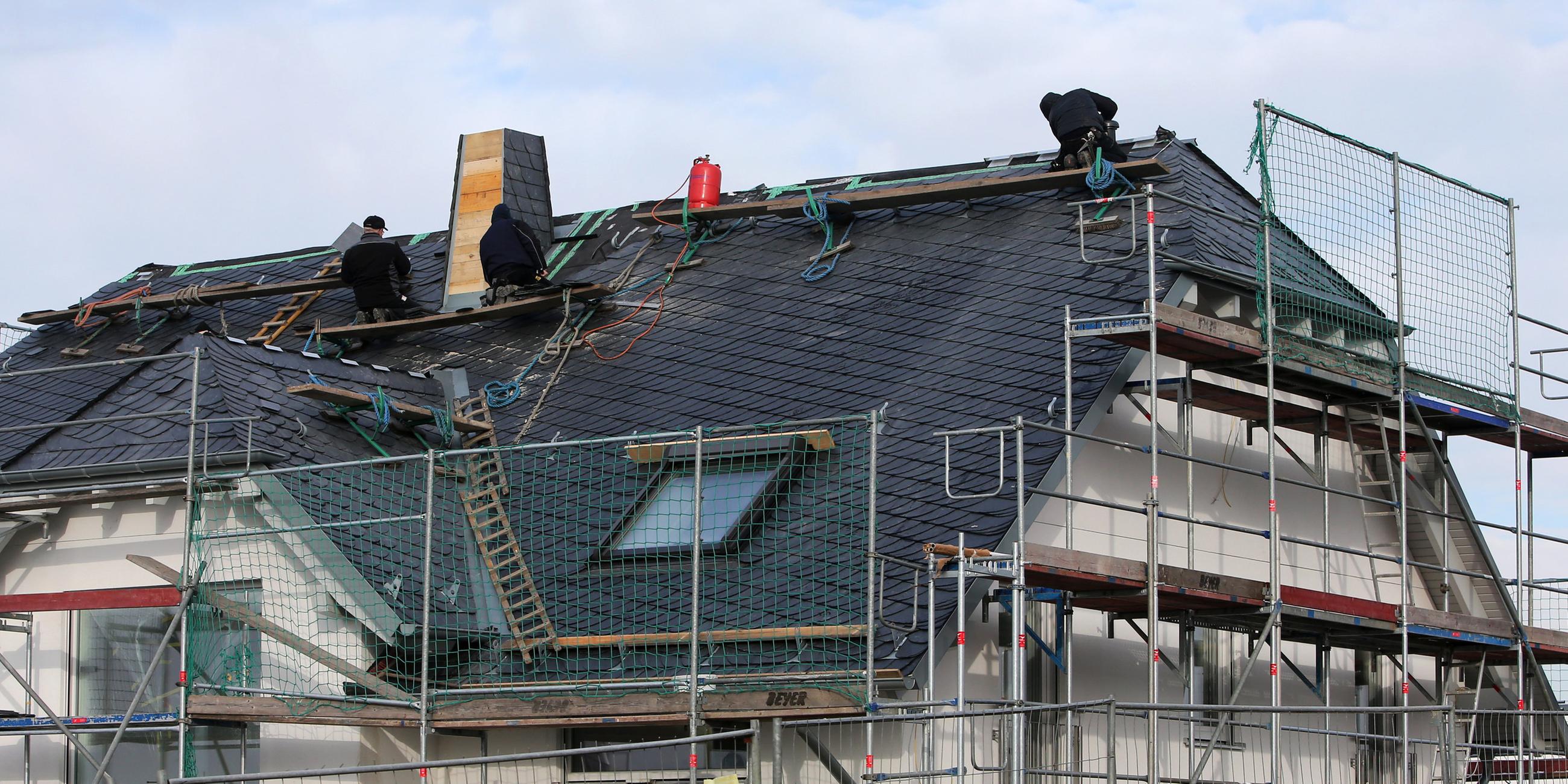 Männer arbeiten in einem Neubaugebiet in Nieder-Olm (Rheinland-Pfalz) am Dach eines Neubaus, aufgenommen am 28.10.2022