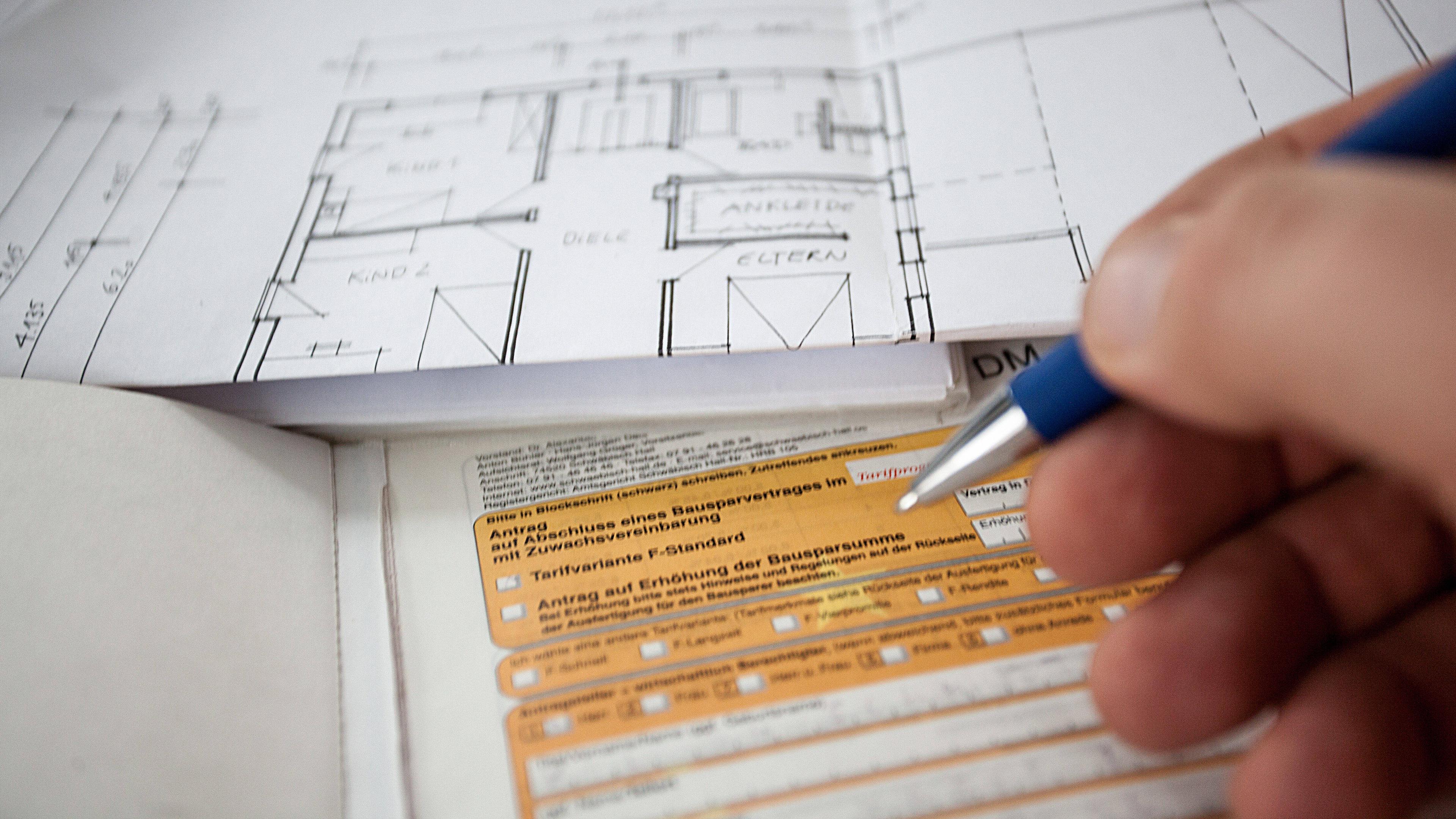Auf einem Schreibtisch liegt ein Antragsformular für einen Bausparvertrag welcher von dem Kunden ausgefüllt werden muss. 