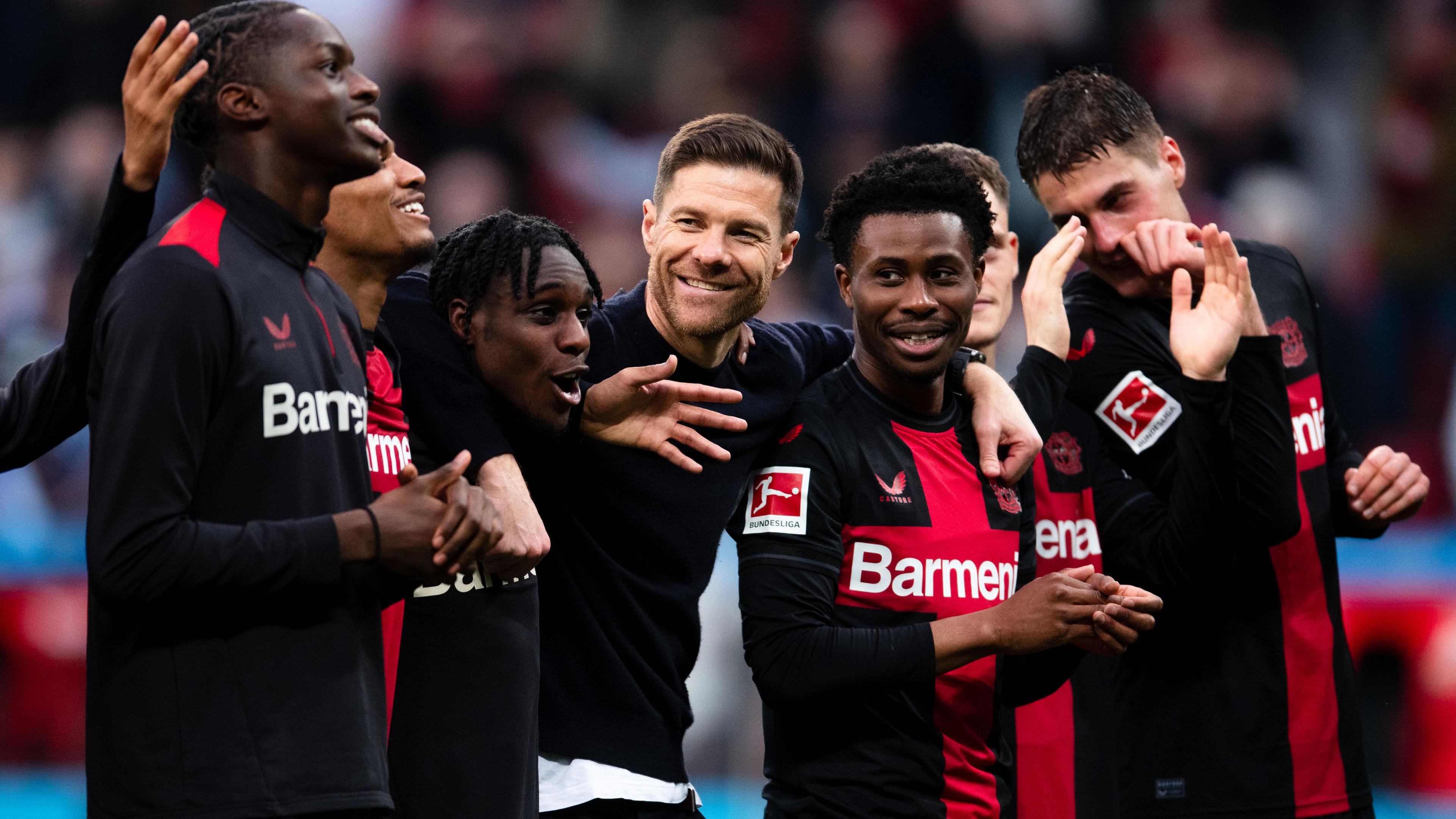 Trainer Xabi Alonso feiert mit seinen Spielern von Bayer Leverkusen
