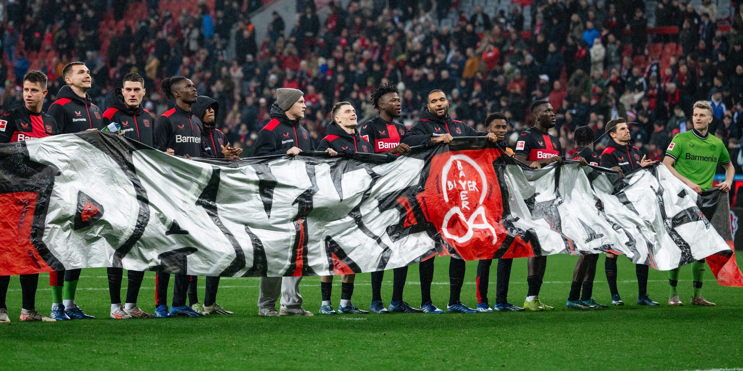 Die Leverkusener Spieler halten nach der Partie ein Banner mit der Aufschrift "Danke Fans" in den Händen am 20.12.2023.