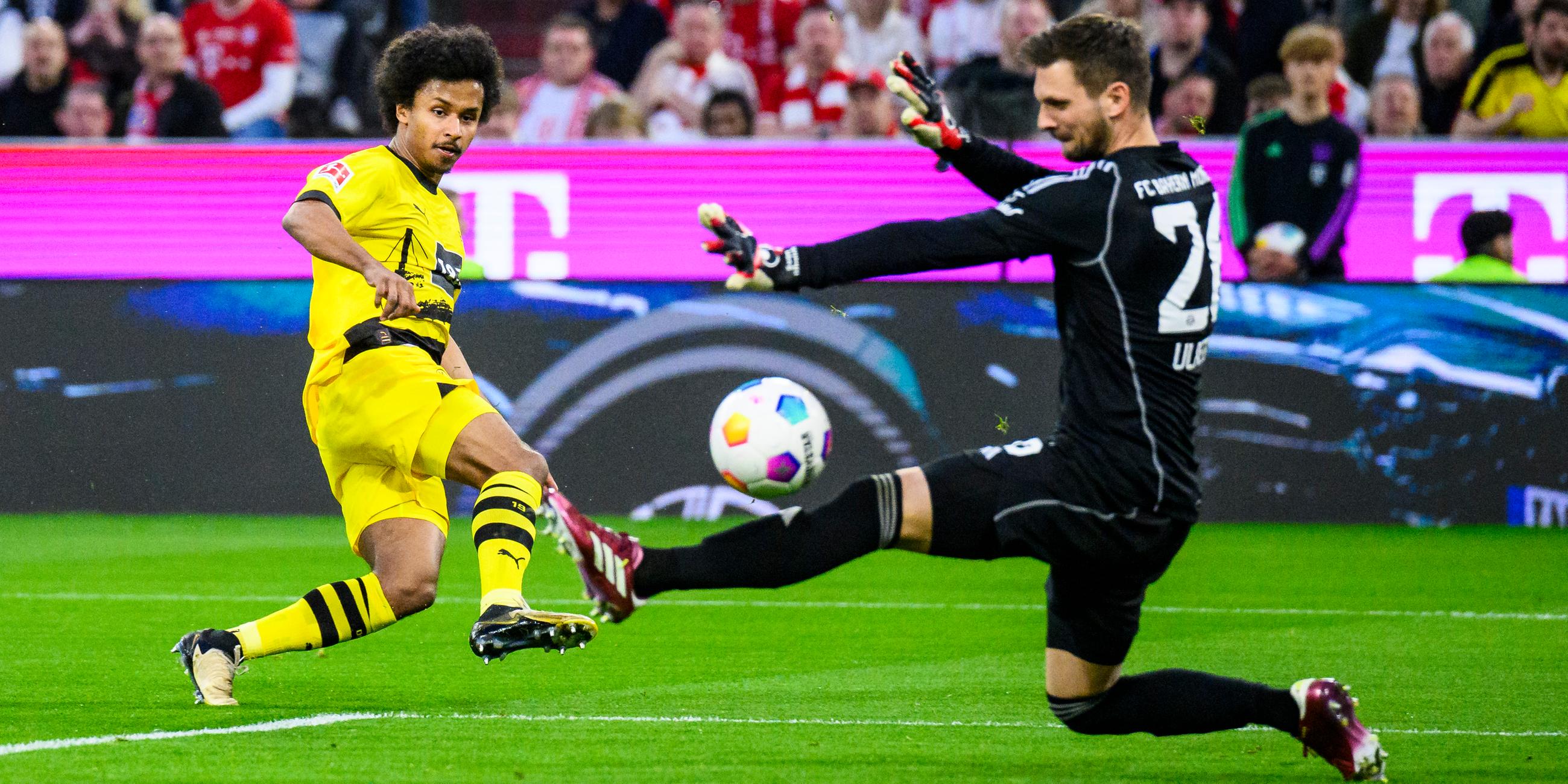 Dortmunds Karim Adeyemi macht das Tor zum 0:1 gegen Münchens Torwart Sven Ulreich.