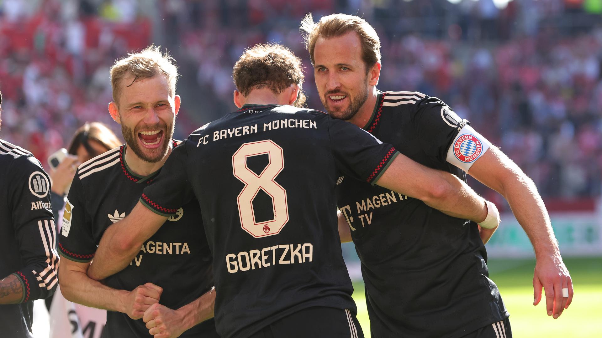 Nach dem 4:3 Sieg gegen den 1. FSV Mainz 05 jubeln Harry Kane, Konrad Laimer und Leon Goretzka zusammen vor der Gästekurve