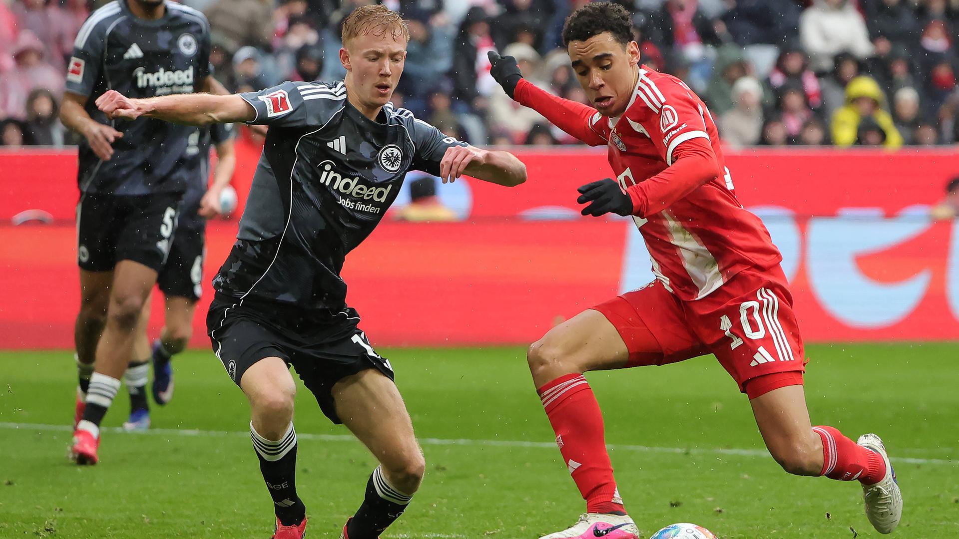 Hugo Larsson (Eintracht Frankfurt) und Jamal Musiala (FC Bayern München) kämpfen. 