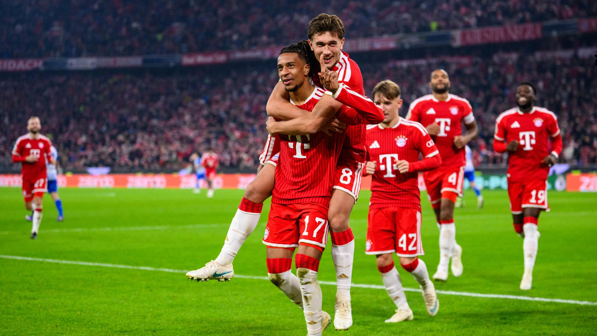 Michael Olise (l.) und Tom Bischof jubeln über das 3:1 für Bayern gegen Magdeburg.