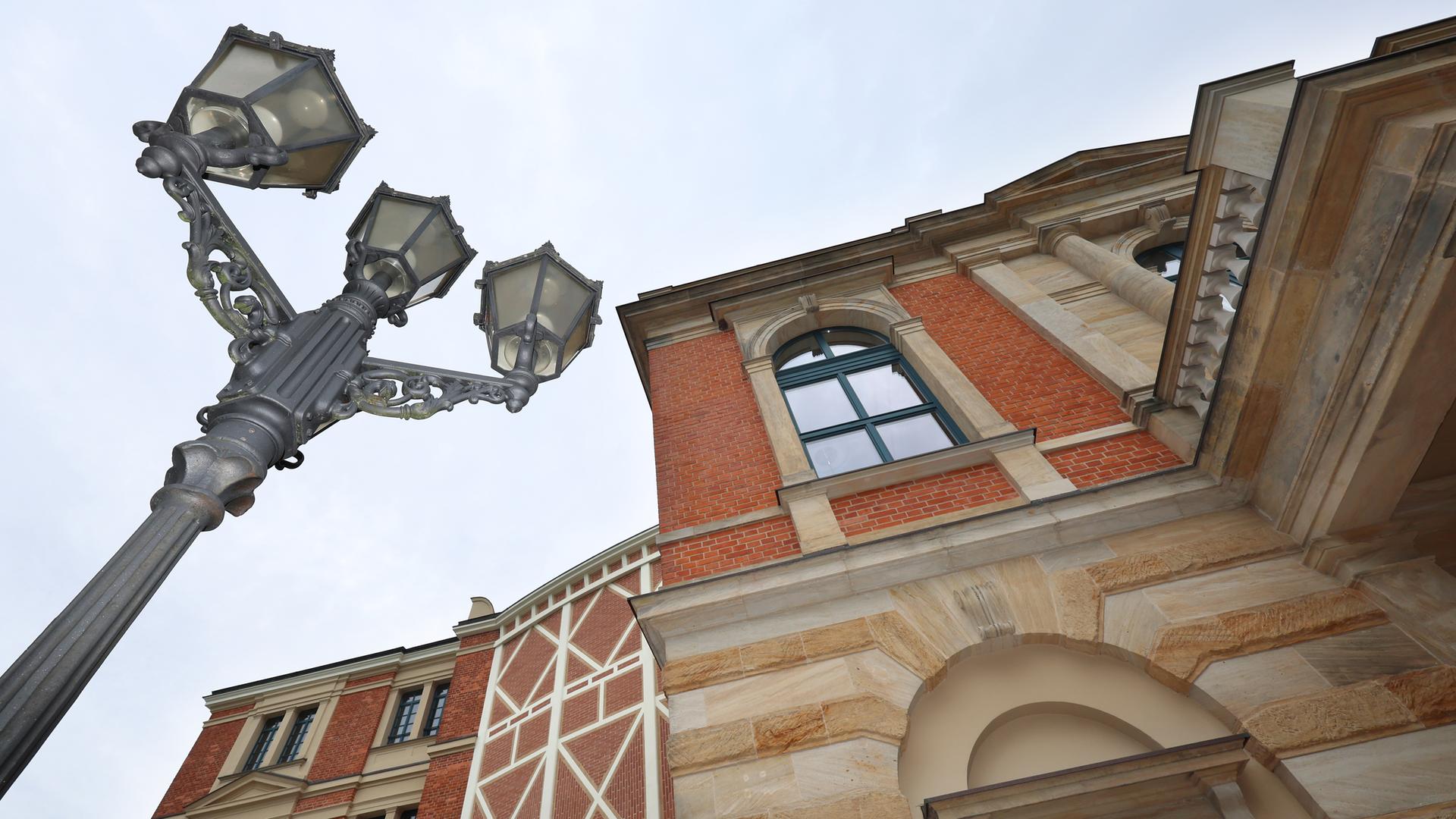 Untersicht auf das Festpielhaus-Gebäude und eine historische Straßenlaterne in Bayreuth.