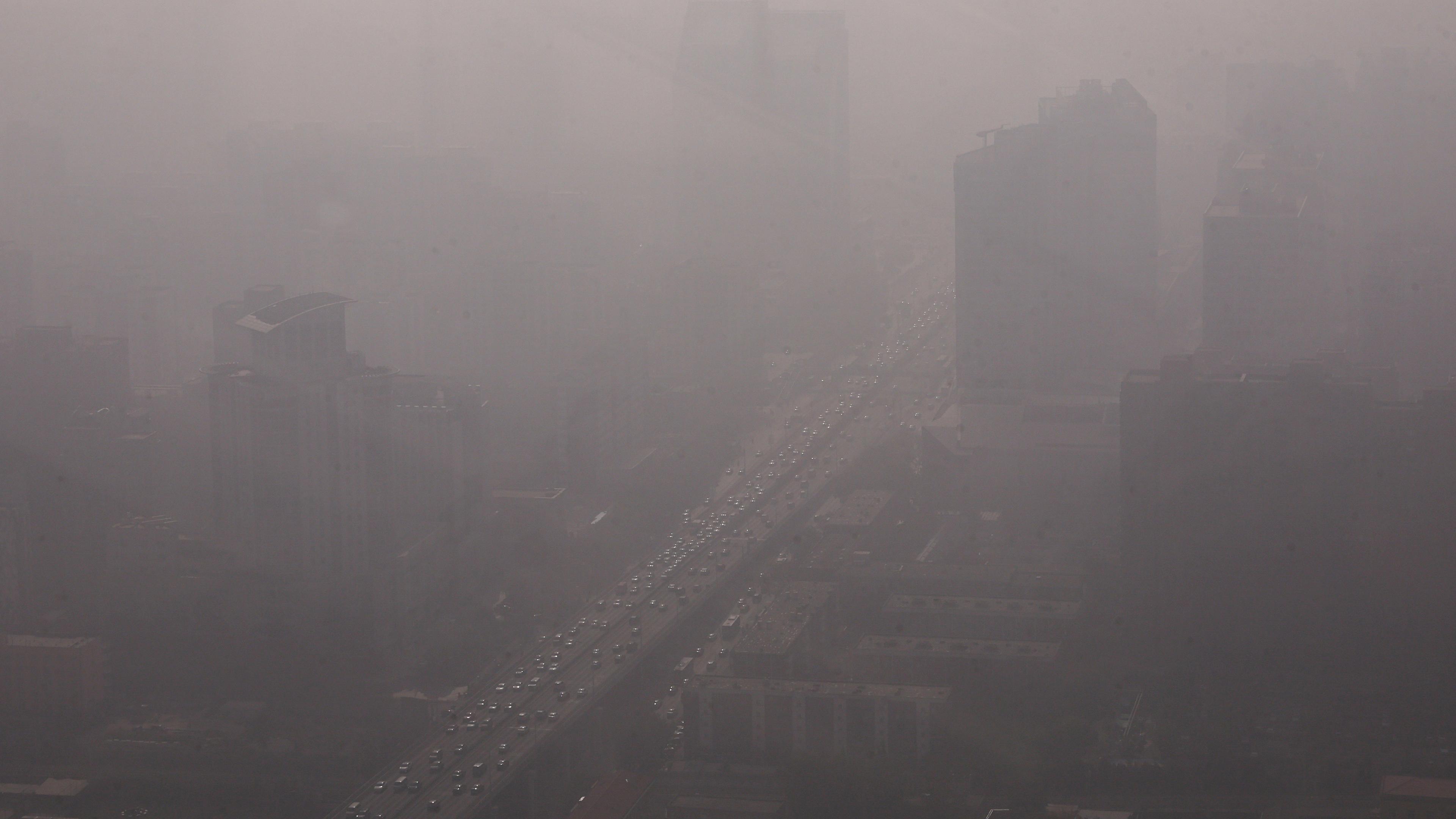 Fahrzeuge bewegen sich auf einer Straße in Pekings Central Business District, während die Stadt in Smog gehüllt ist am 01.11.2023.