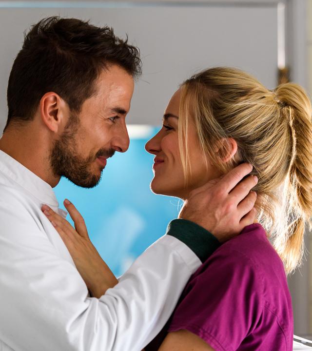 "Bettys Diagnose - Bekenntnisse": Dr. Frank Stern (Max Alberti) und Betty Weiss (Annina Hellenthal) sehen sich lächelnd in die Augen, während sie dicht voreinander stehen.