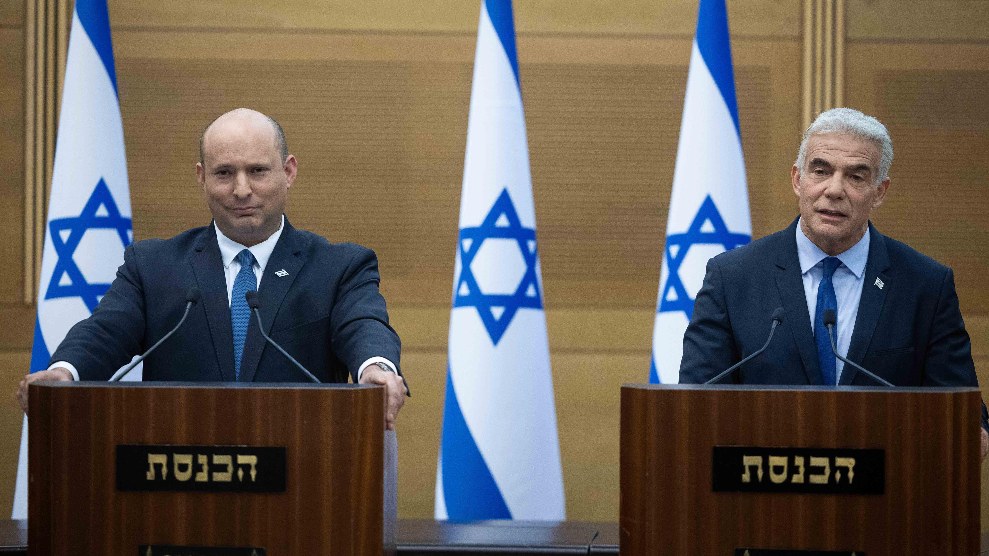 Israel, Jerusalem: Naftali Bennett (l), Ministerpräsident von Israel, spricht während einer gemeinsamen Erklärung mit Jair Lapid, Außenminister von Israel, in der Knesset.