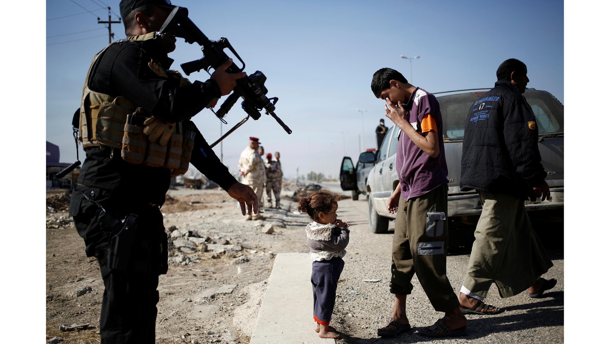 Ein kleines barfüßiges Mädchen steht an einem Checkpoint der irakischen Armee in Kokjali