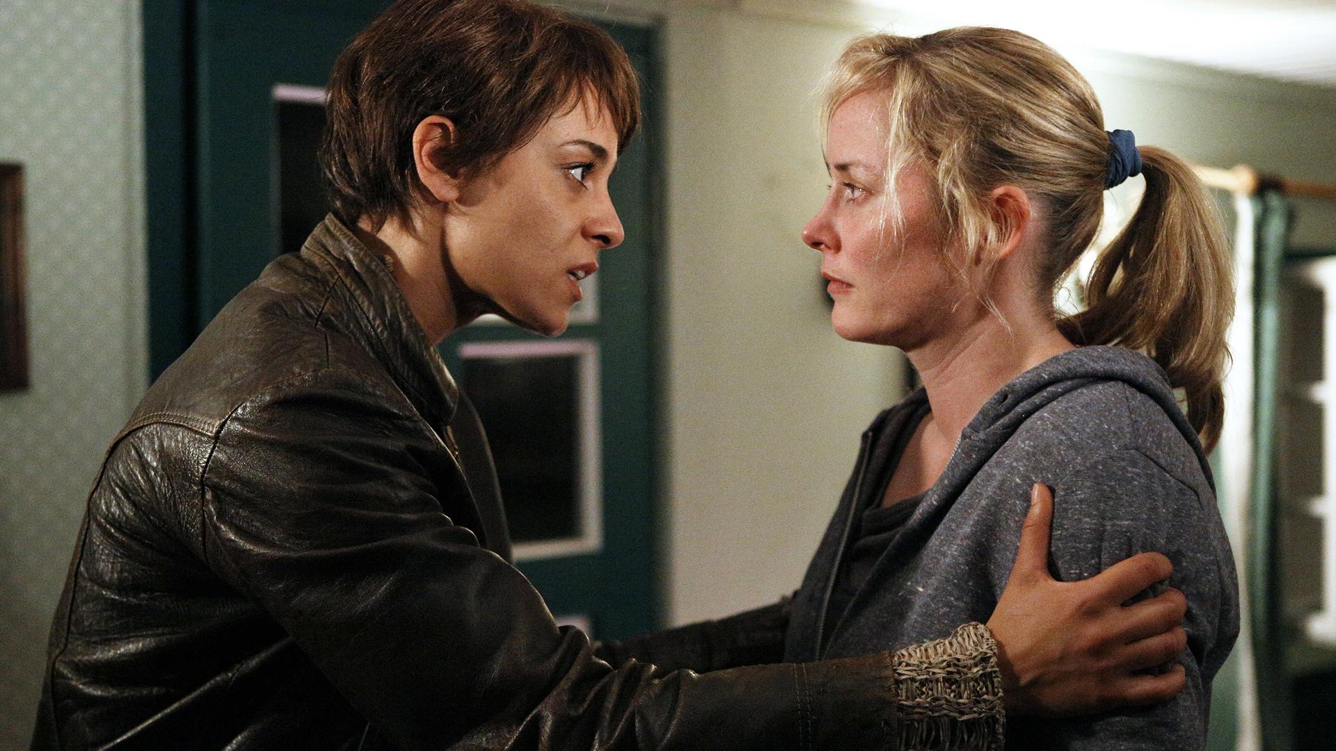 Manu (Edita Malovcic) hält ihre Freundin Charly (Silke Bodenbender) an den Oberarmen umfasst und redet eindringlich auf sie ein.