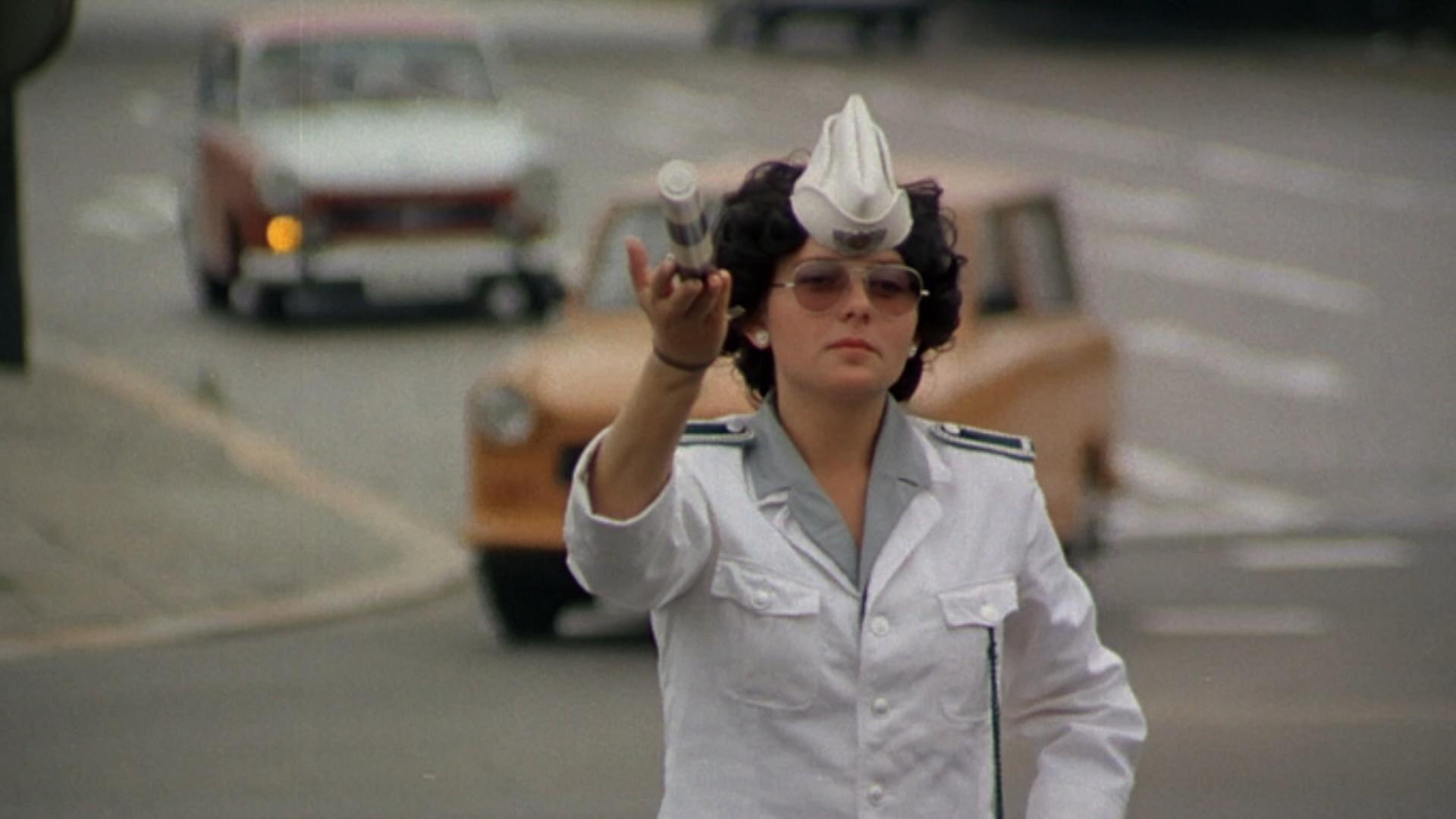 "Berlin, Berlin - Kripo, Vopo, Freund und Helfer": Polizistin in Ost-Berlin, zirka 1980, regelt auf der Straße den Verkehr.