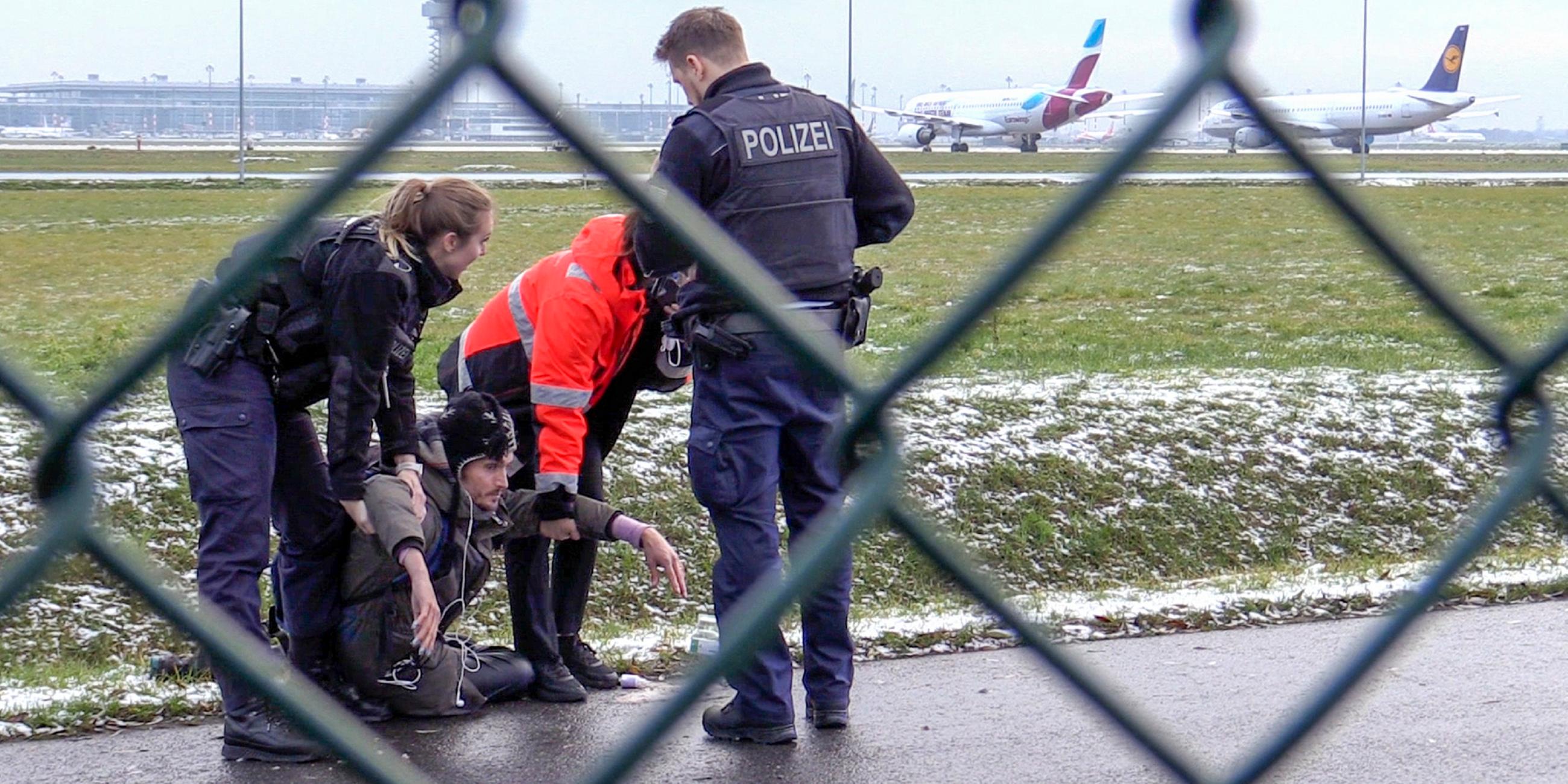 Brandenburg, Schönefeld: Zwei Beamte der Bundespolizei und ein Sicherheitsmitarbeiter steht mit einem sichergestellten Bolzenschneider an einem Zaun am BER-Flughafen.