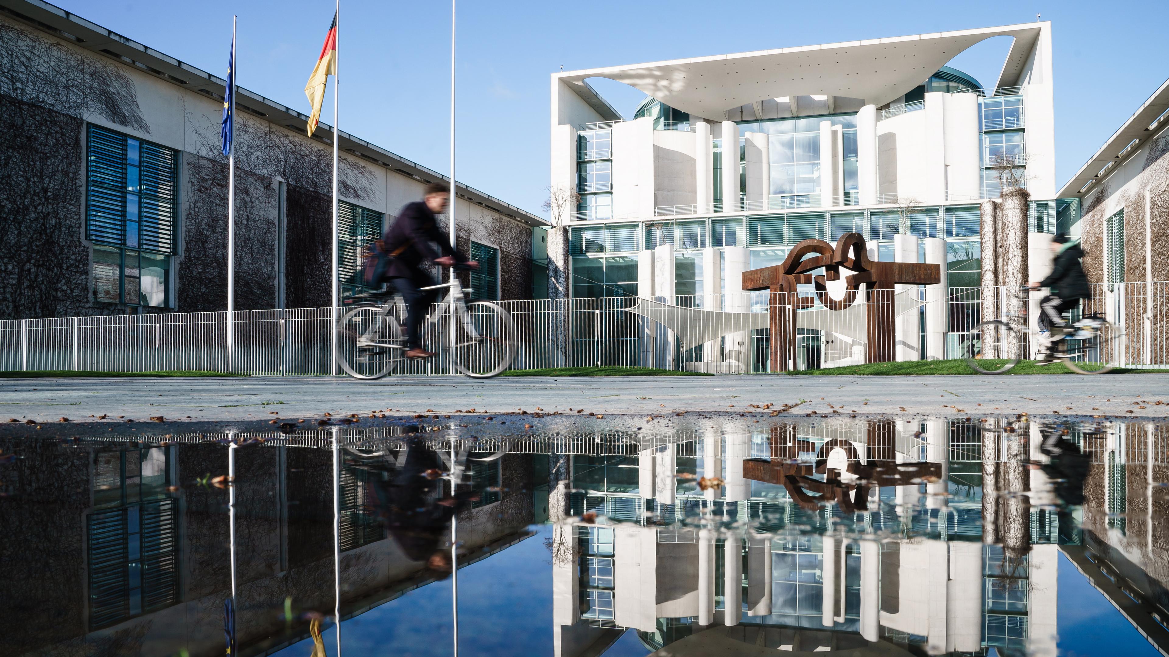 Das Kanzleramt spiegelt sich in einer Pfütze in Berlin, Deutschland.