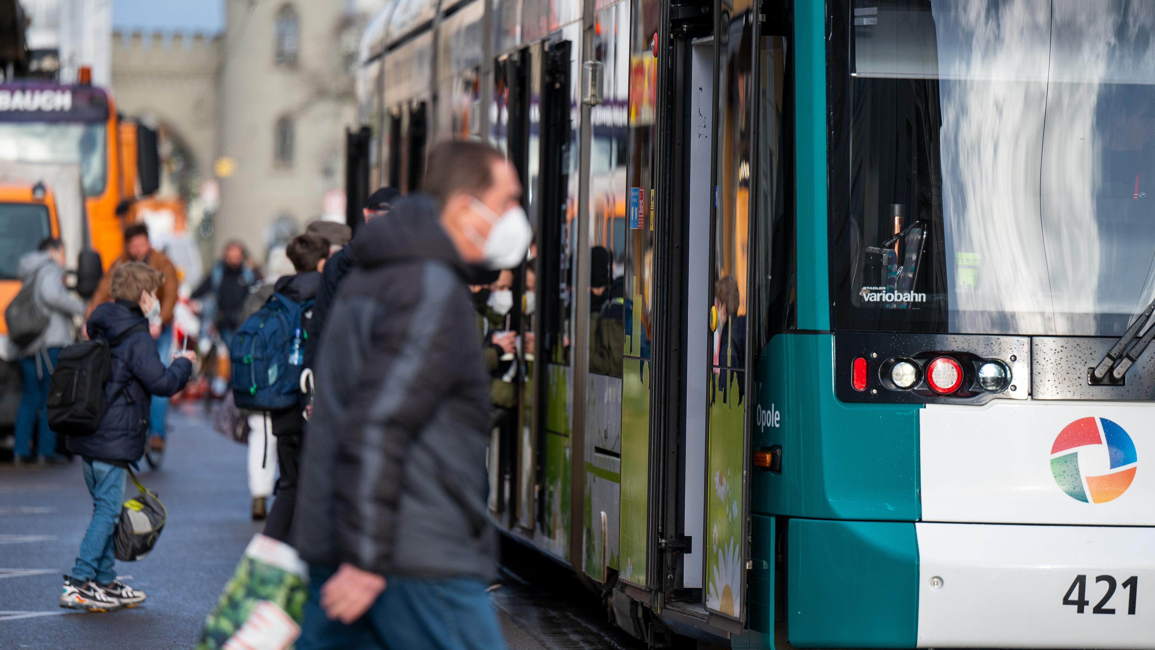 Brandenburg, Potsdam: Fahrgäste mit FFP2-Masken steigen in eine Straßenbahn in der Innenstadt von Potsdam ein.