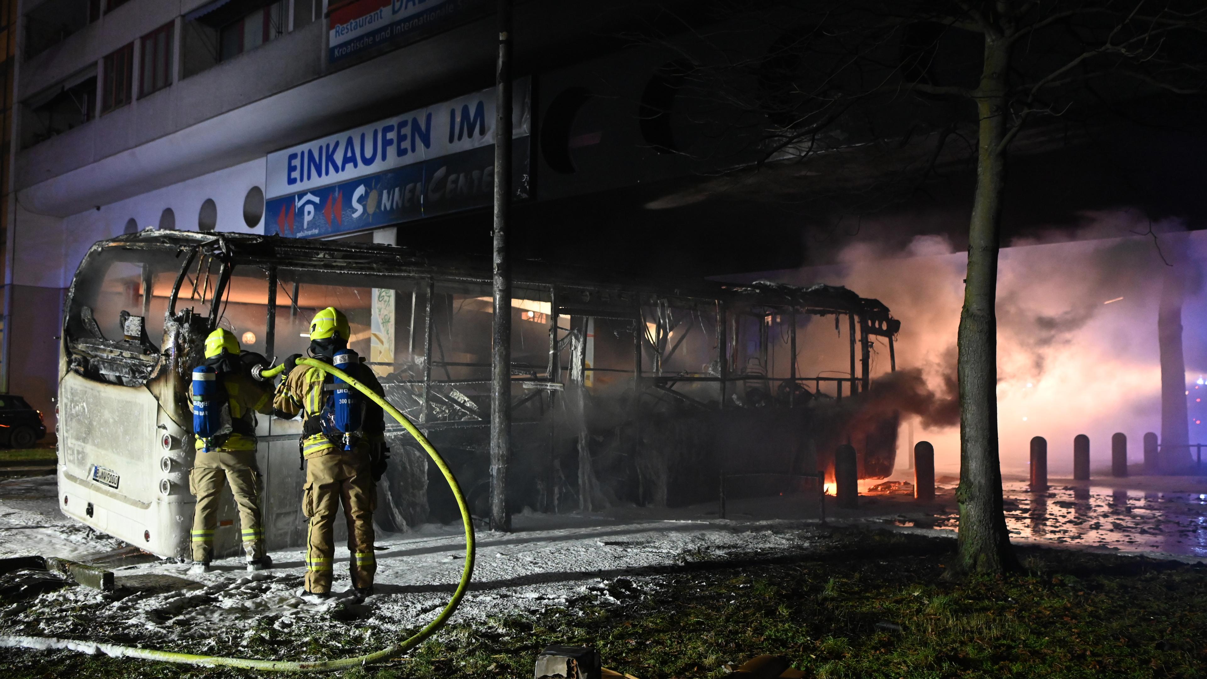 Berlin: Feuerwehrmänner löschen an der Sonnenallee einen Reisebus, der von Unbekannten angezündet worden war.