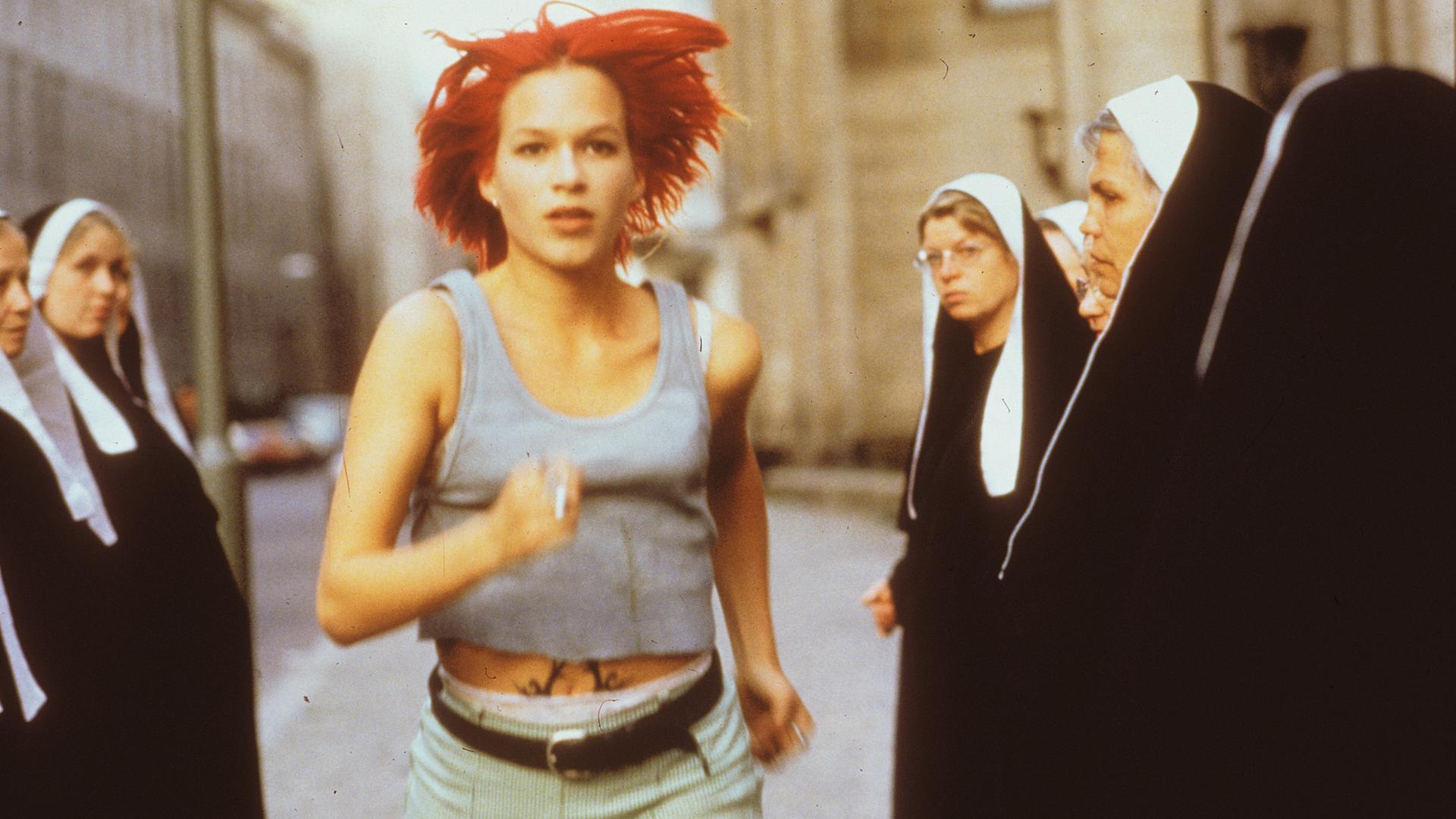 Eine Frau rennt durch eine Gruppe von Nonnen