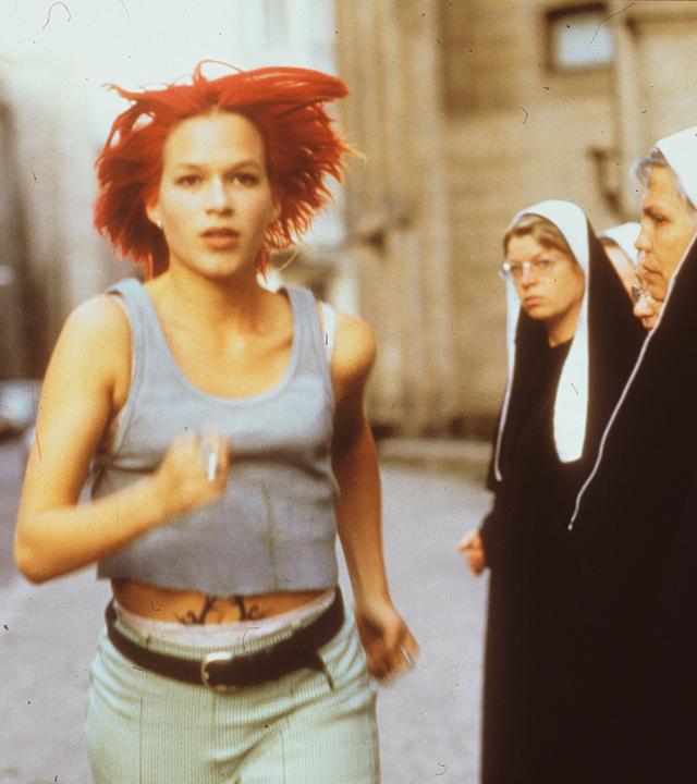 Eine Frau rennt durch eine Gruppe von Nonnen