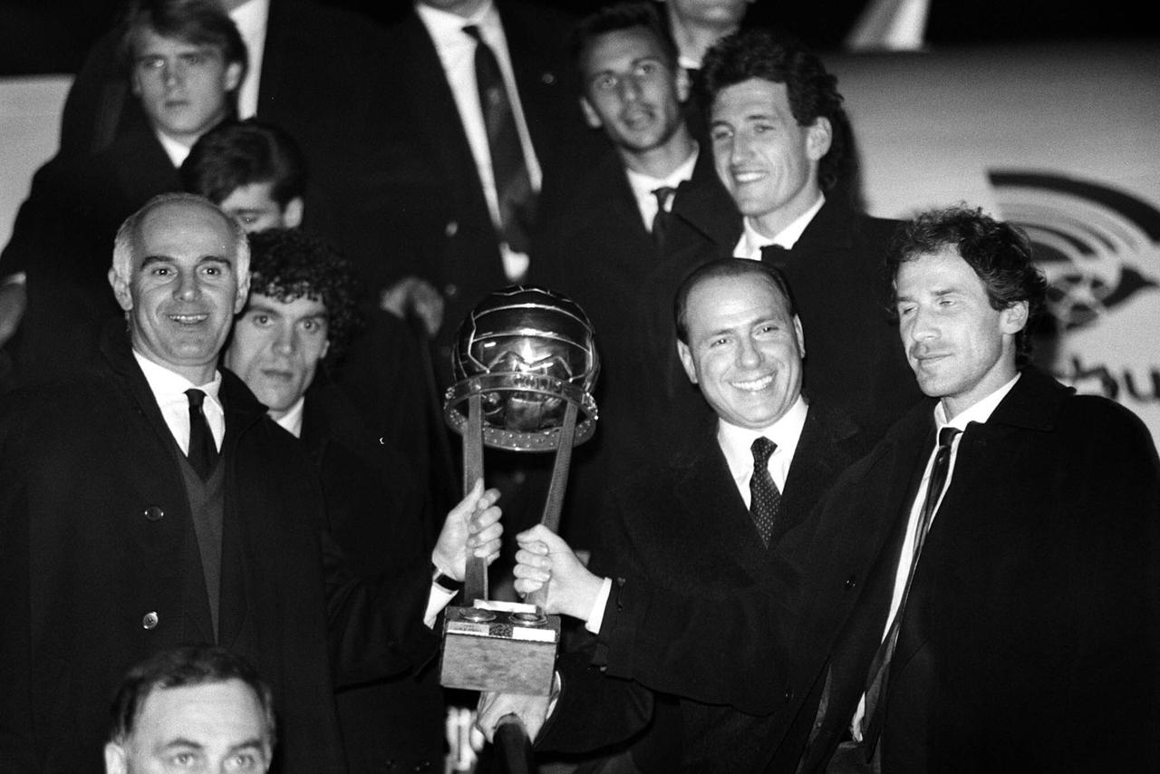 Der ehemalige Trainer des AC Mailand, Arrigo Sacchi, der Präsident des AC Mailand, Silvio Berlusconi, und Franco Baresi zeigen den Intercontinental Cup bei ihrer Ankunft auf dem Flughafen Mailand-Linate im Dezember.