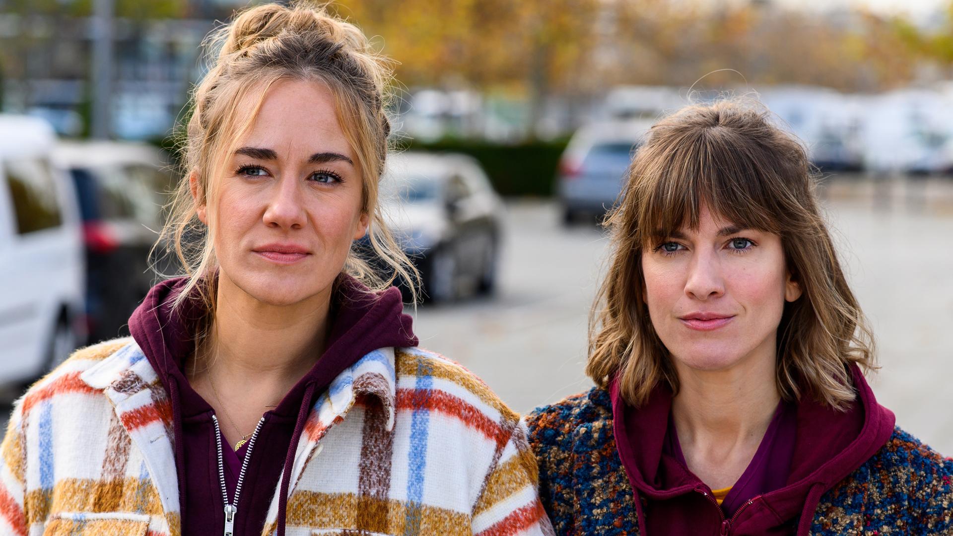 Betty (Annina Hellenthal) und Rike (Isabell Horn) laufen auf dem Krankenhausparkplatz gedankenverloren nebeneinander her.