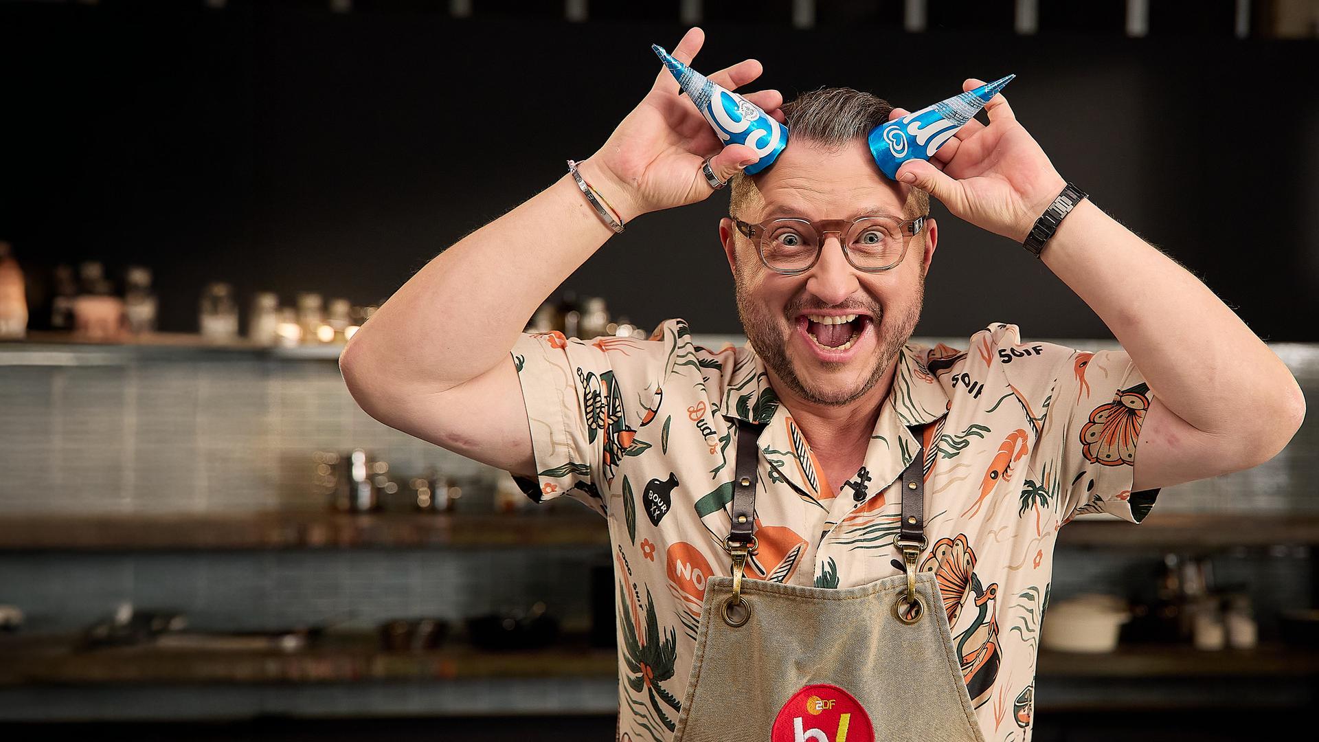 Sebastian Lege, wie er sich zwei Langnese Eiscreme-Verpackungen als Hörner an die Stirn hält.
