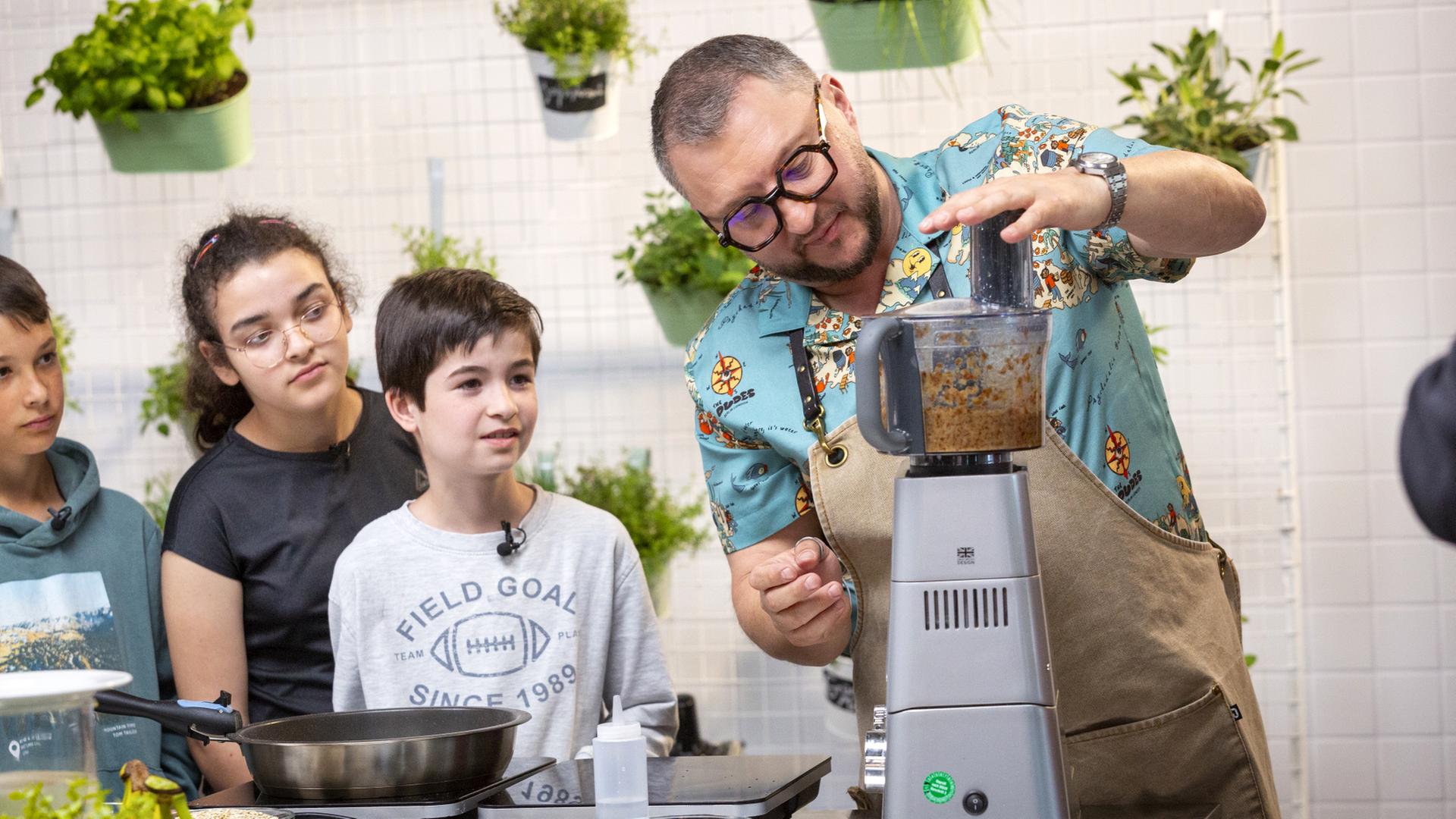 ZDFbesseresser Sebastian Lege mit Kindern der Wilhelm-Lehmbruck-Schule in seiner Küche