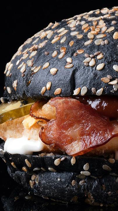 Das Bild zeigt einen Burger, ein Logo und ein Getränk.