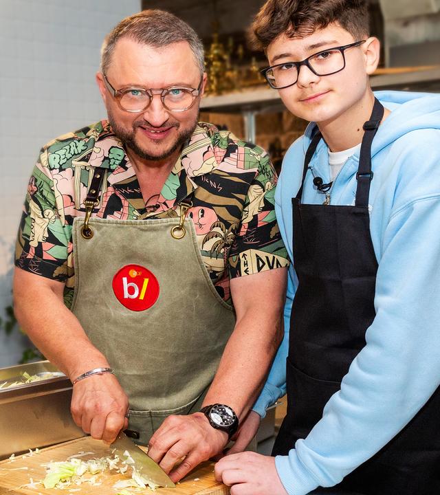 besseresser Kids - Lege packt´s an: Sebastian Lege steht gemeinsam mit einem Schüler in der Schulküche und schnippelt Gemüse. 