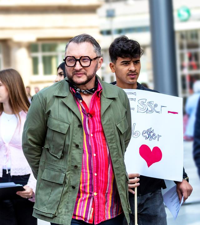 Sebastian Lege steht mit Schulkindern auf einer Demonstration für kostenloses Schulessen.