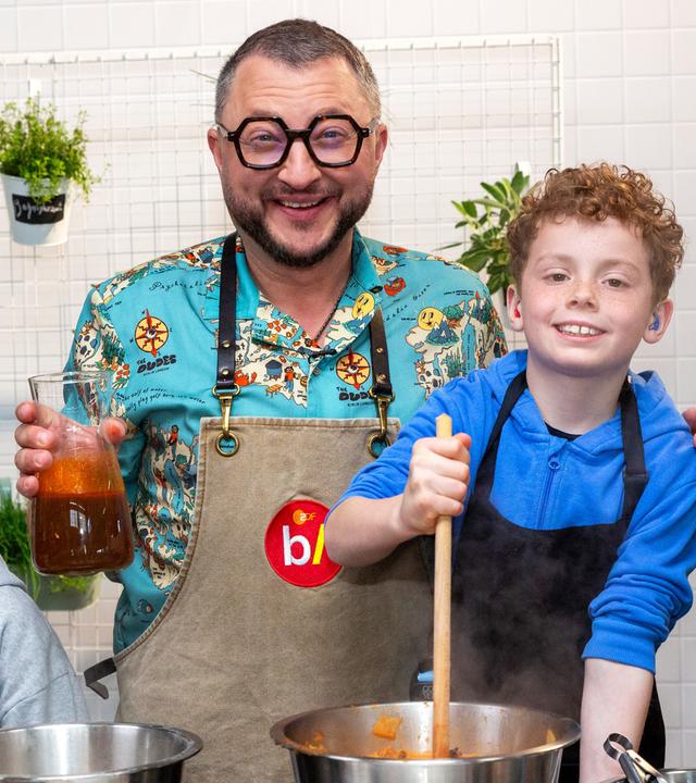 besseresser kids: Lege packt´s an: Sebastian Lege steht mit zwei Schülern am Herd und vor den Kochtöpfen. 