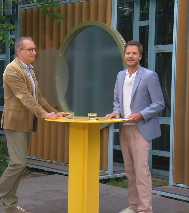 Dr. Christoph Specht und Florian Weiss stehen an einem Tisch im "Volle Kanne"-Atrium