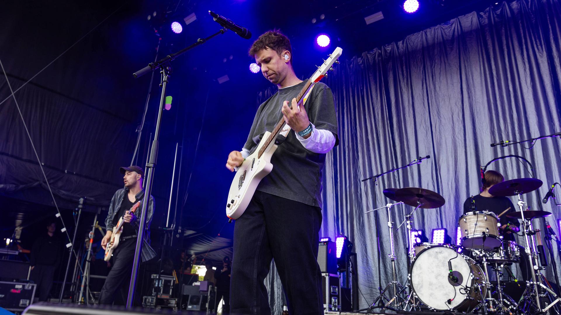 Zwei Musiker stehen auf einer Bühne und spielen Gitarre.